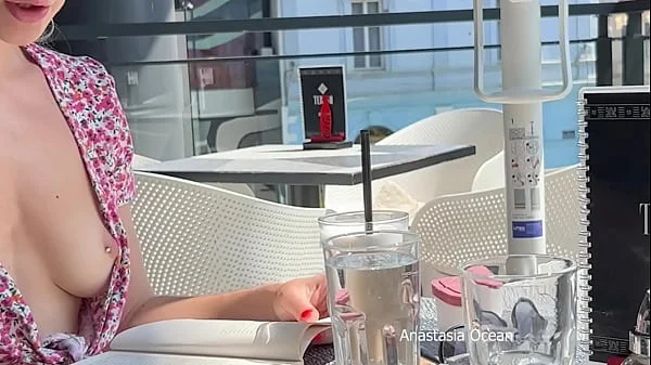 Cute girl reads a book in cafe with no bra with her nipple out. Downblouse. Public flashing.