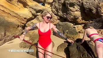 Blonde Mistress Canes Slave in Bikini on Beach