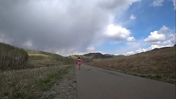 Mature milf with naked charms walks on a public road outdoors. Exhibitionist with a gorgeous ass and hairy pussy. PAWG and amateur fetish.